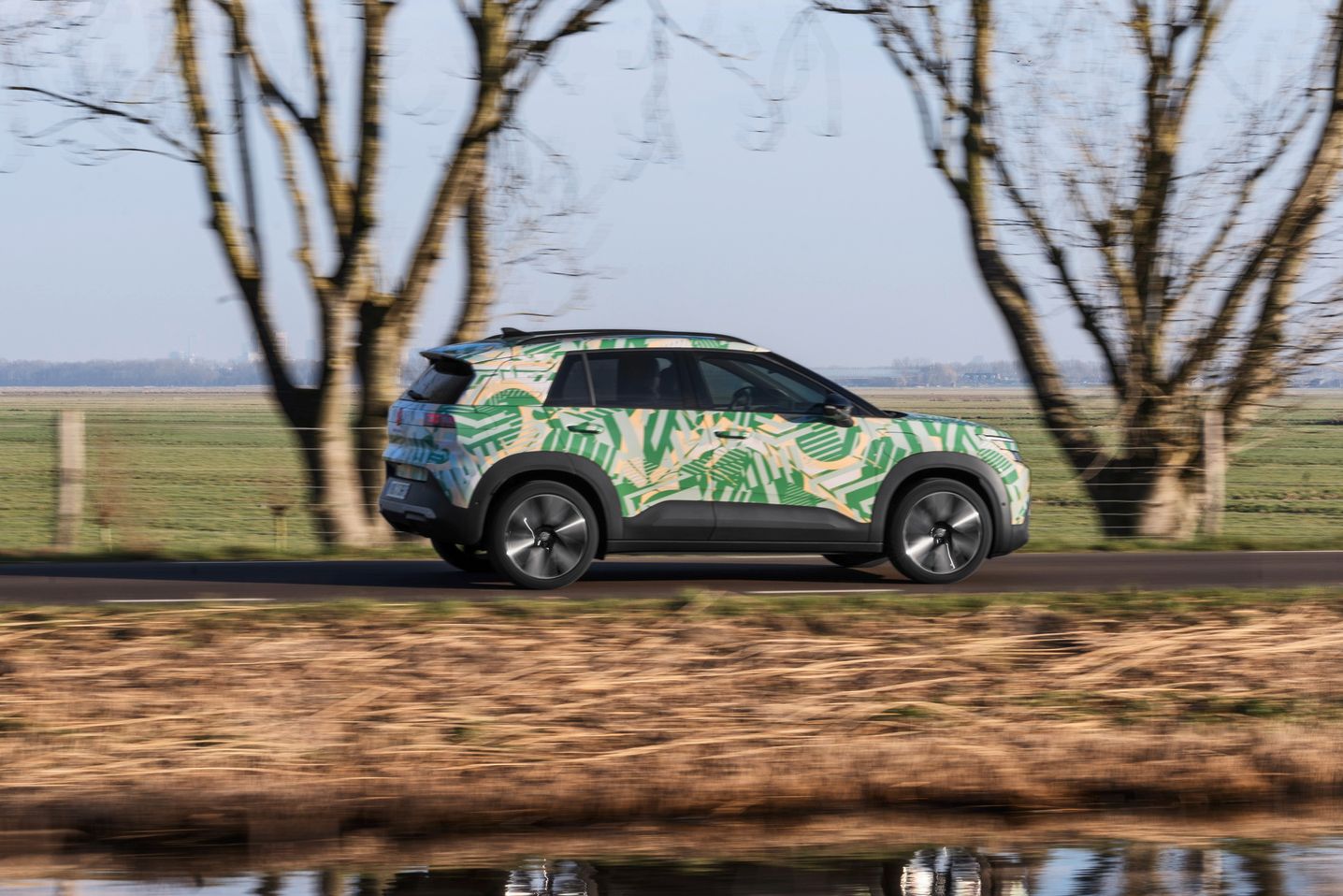 Um VW ID. Cross visto de perfil a circular numa estrada rural.