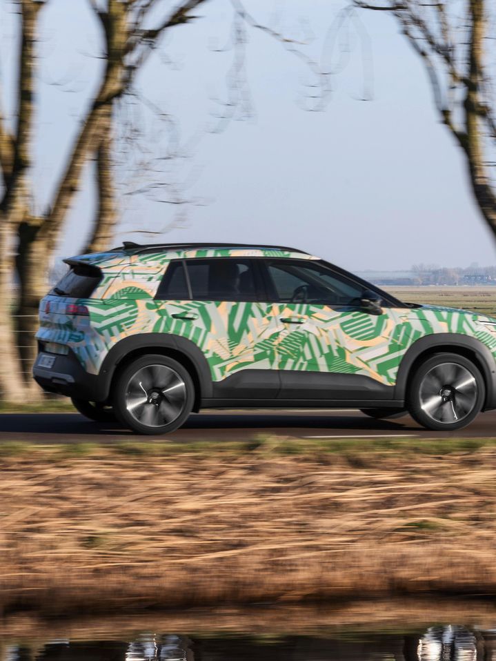 Um VW ID. Cross visto de perfil a circular numa estrada rural.