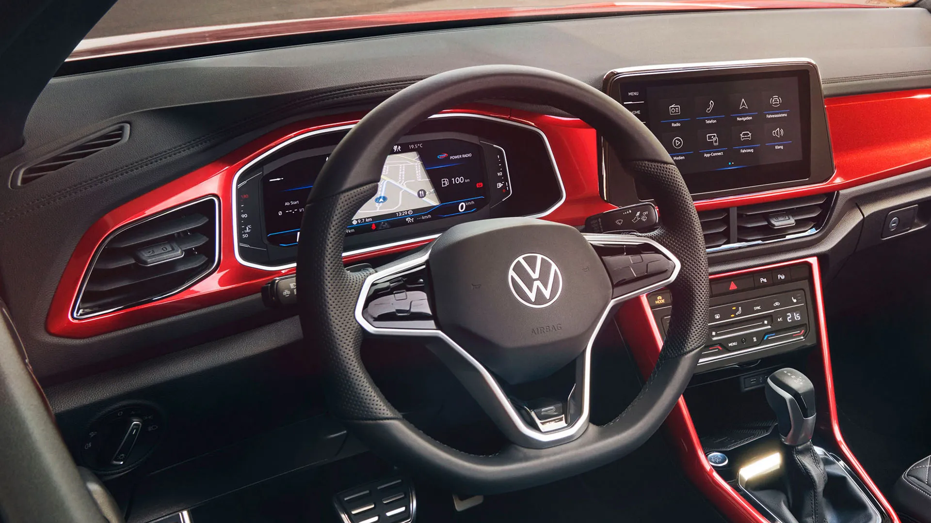 Vista do cockpit do T-Roc Cabrio vermelho, com o volante multifunções, rádio e Digital Cockpit.