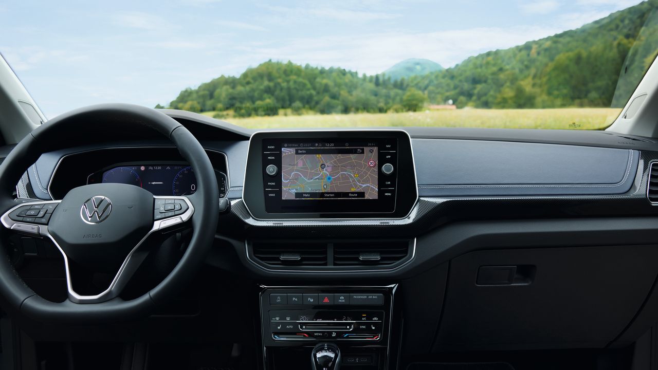 Vista detalhada do cockpit de um VW T-Cross por trás do volante. 