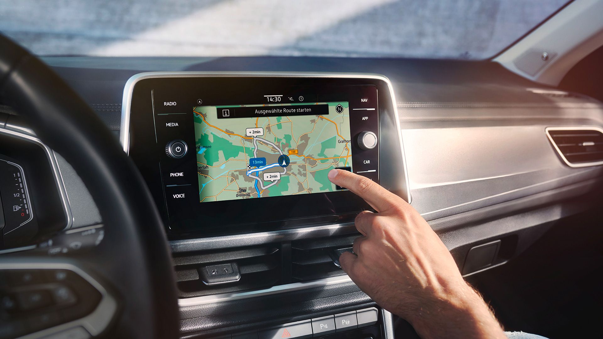 Interior do VW T-Roc, vista de pormenor do sistema Infotainment Discover Media, com uma mão a comandá-lo