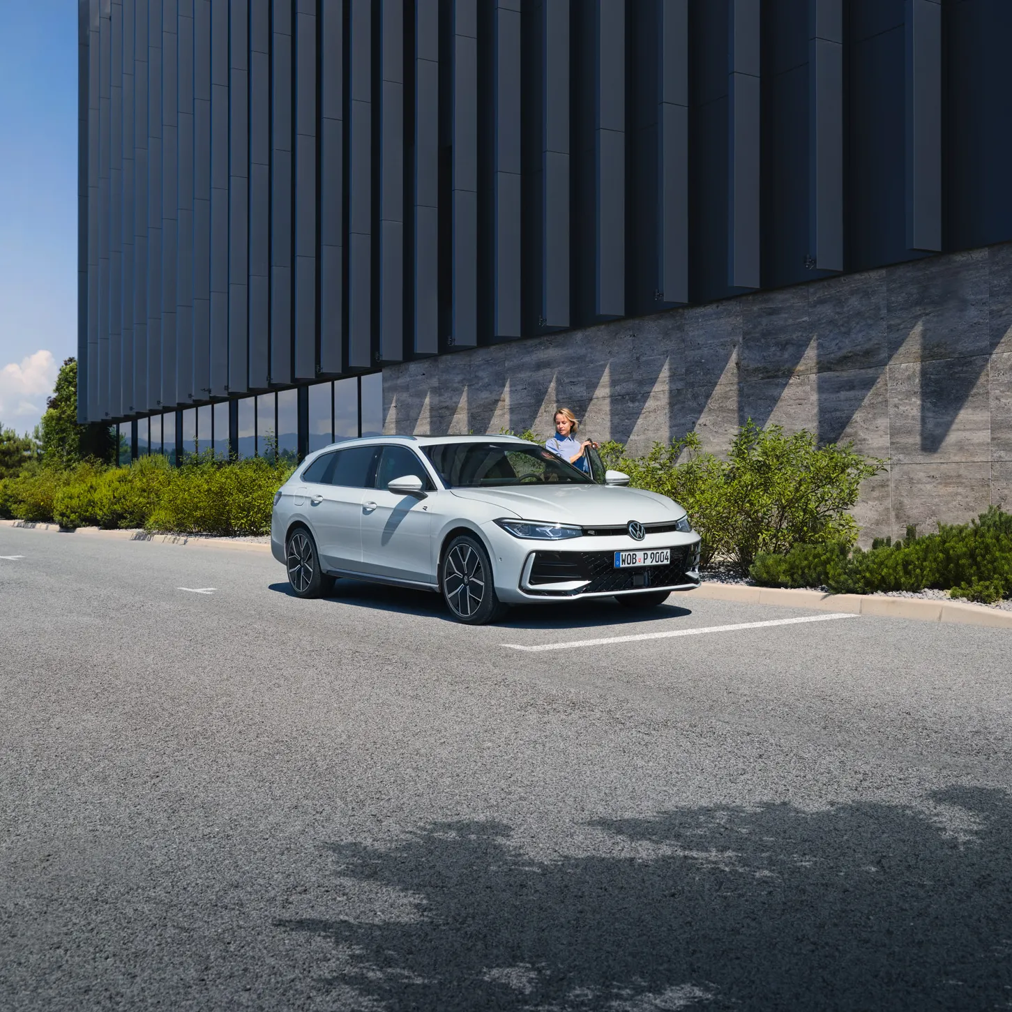 VW Passat branco estacionado à frente de um edifício.