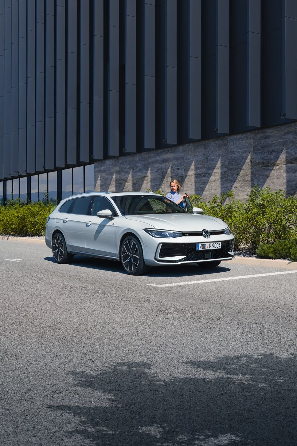 VW Passat branco estacionado à frente de um edifício.