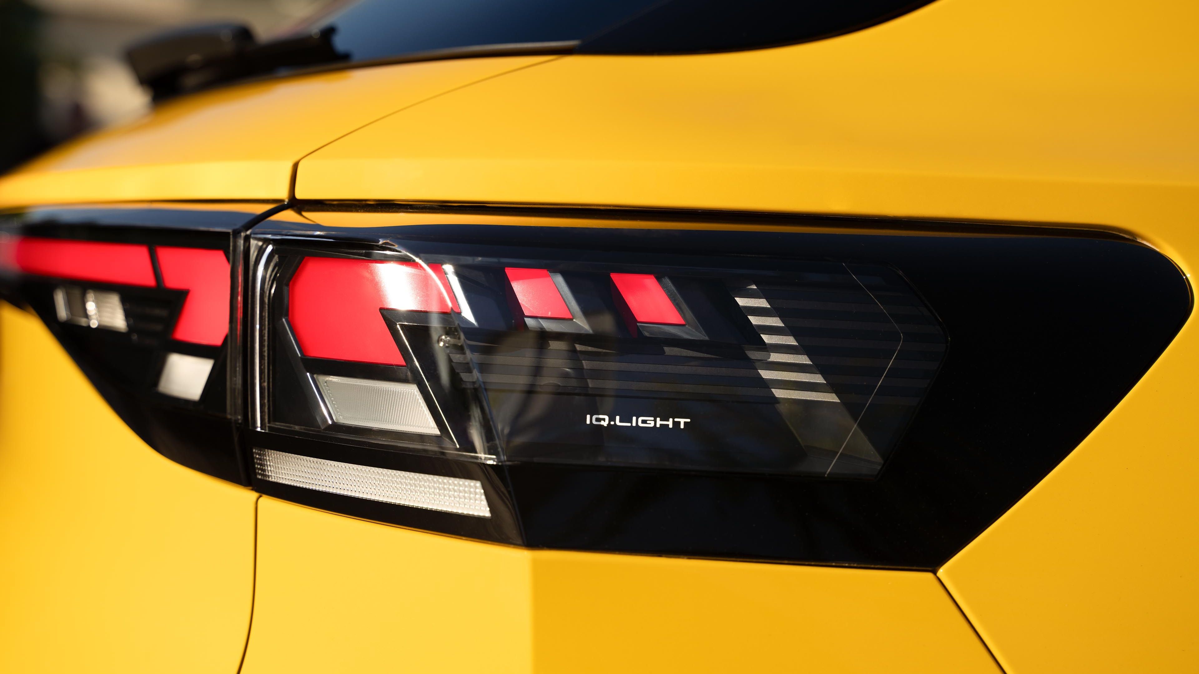 Vista detalhada dos farolins traseiros IQ.LIGHT num VW T-Roc R-Line amarelo.