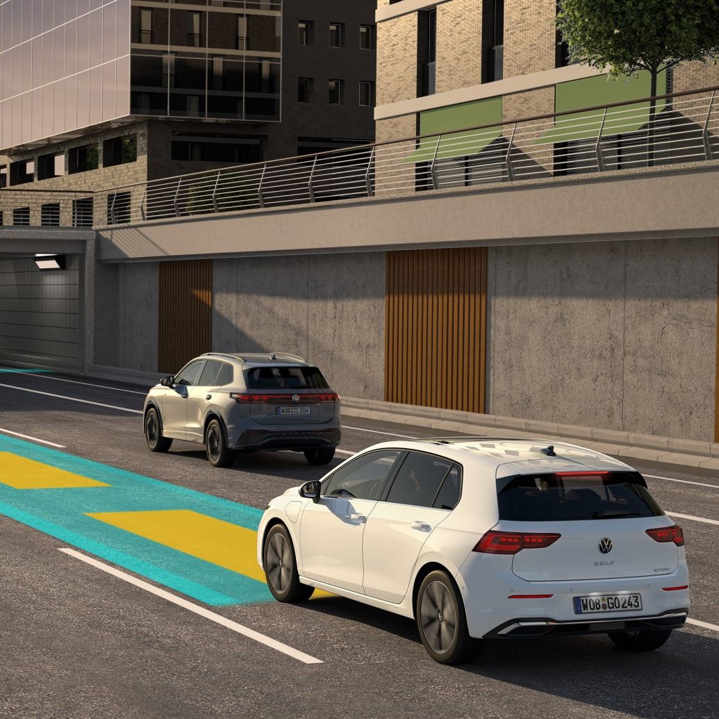 Weißer VW Golf bewegt sich im Straßenverkehr, dabei wird der optionale Travel Assist genutzt und im Bild schematisch dargestellt.