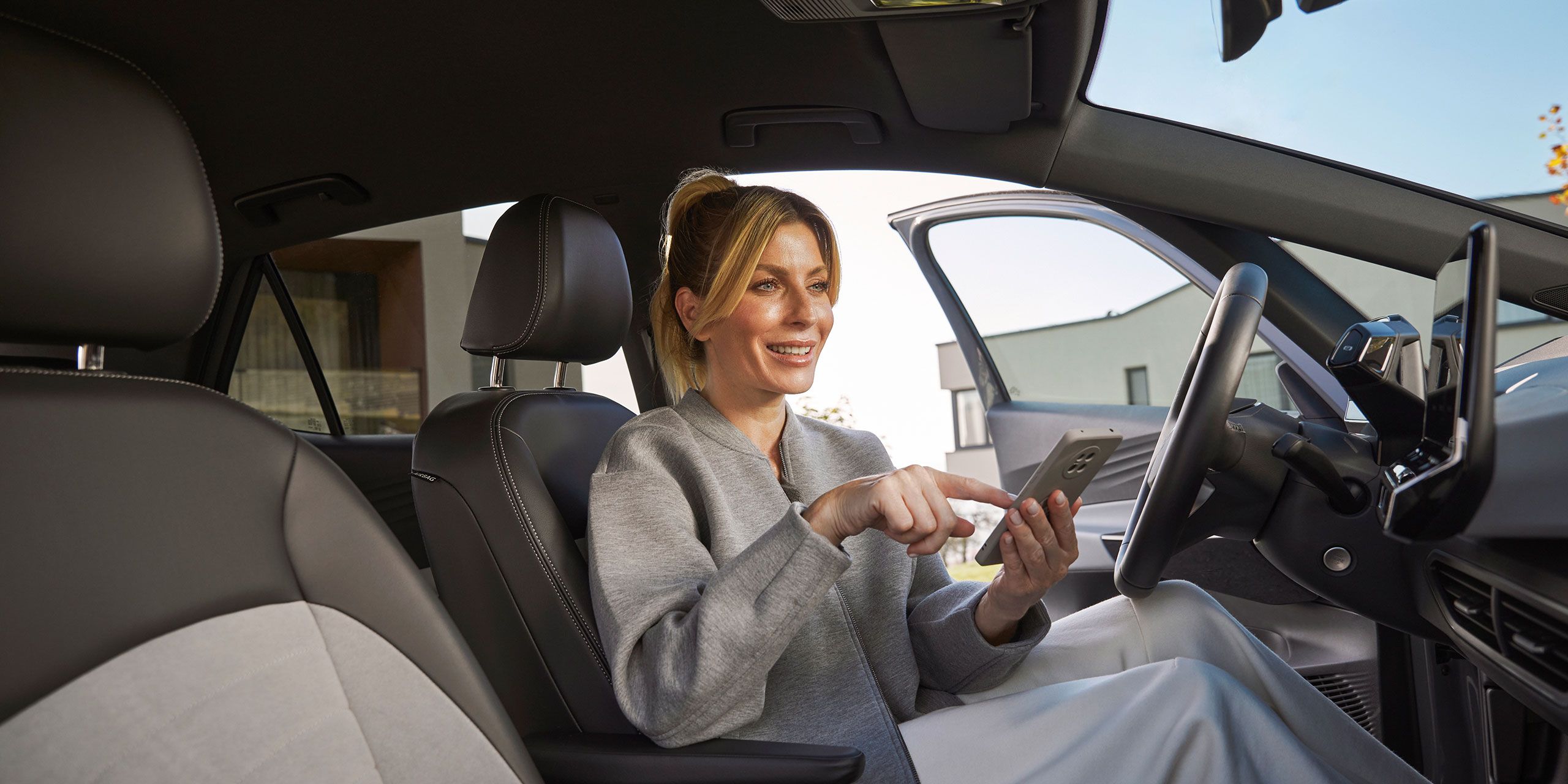 Senhora dentro de um volkswagen a mexer no telemóvel