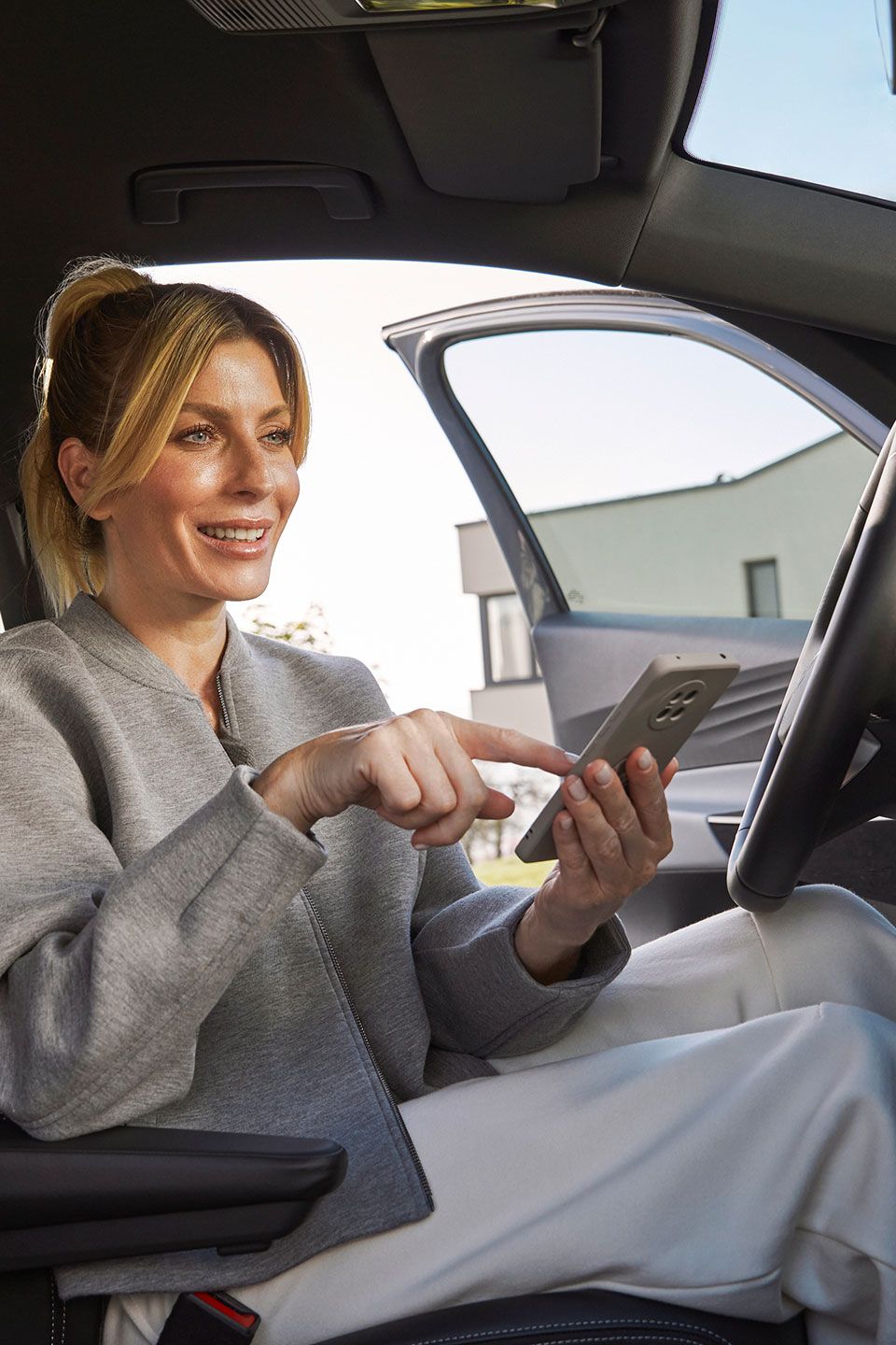 Senhora dentro de um volkswagen a mexer no telemóvel