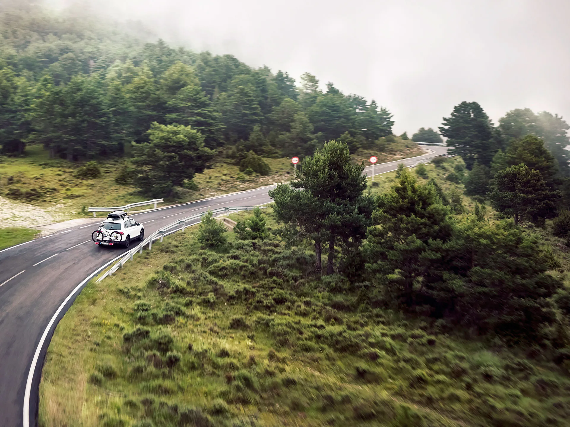 Volkswagen branco em viagem por uma estrada rodeada de vegetação
