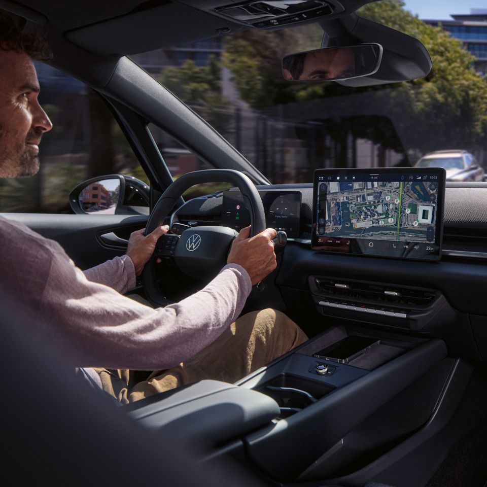 Ein Mann fährt einen VW ID.3 Neo, geleitet von der Online- Navigation auf dem Center-Display
