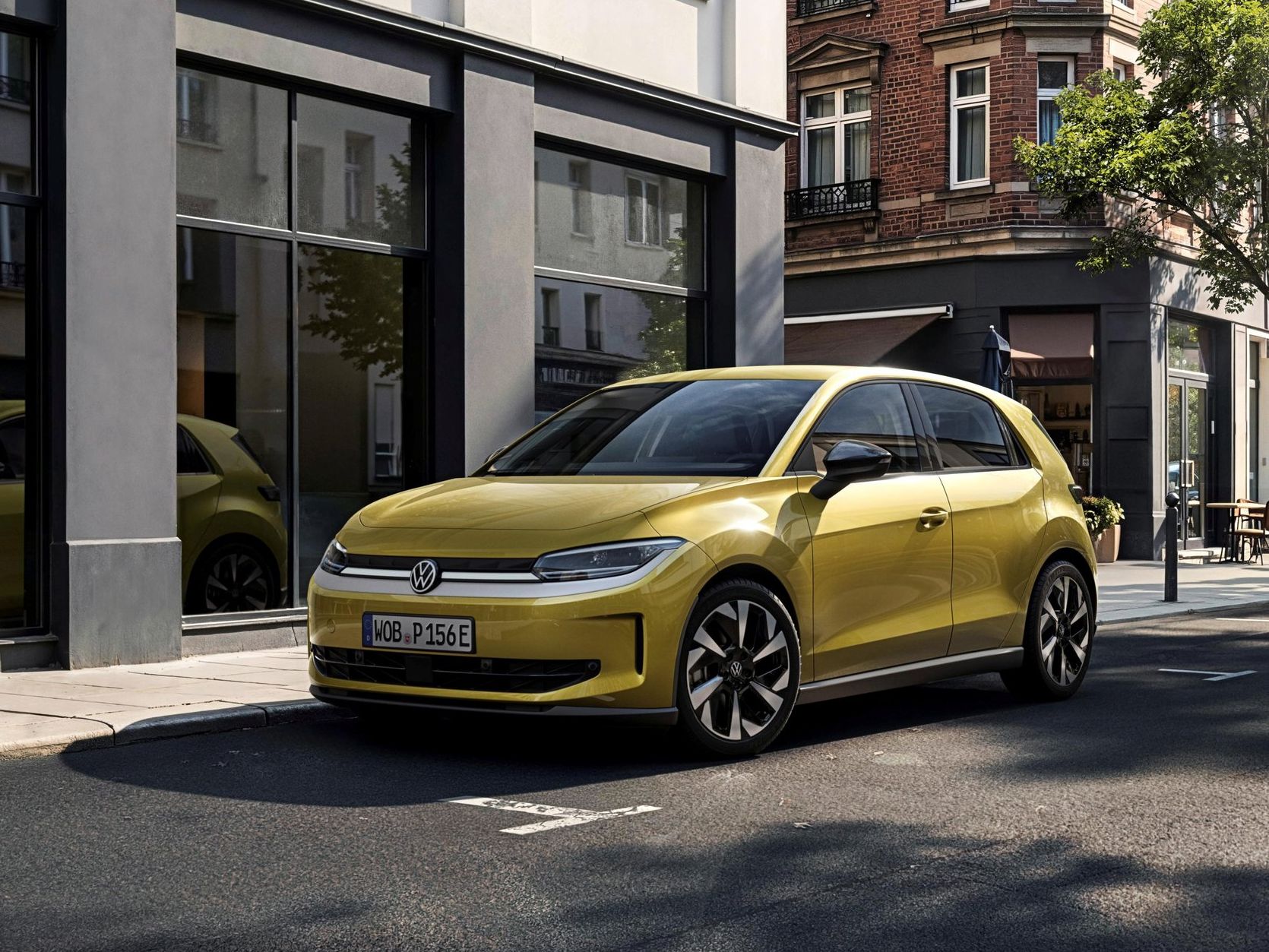 Novo ID. Polo estacionado numa rua urbana. O veículo tem design moderno, exterior amarelo com linhas suaves, rodas desportivas e vidros escurecidos. Ao fundo, vêem-se prédios de fachada clássica.