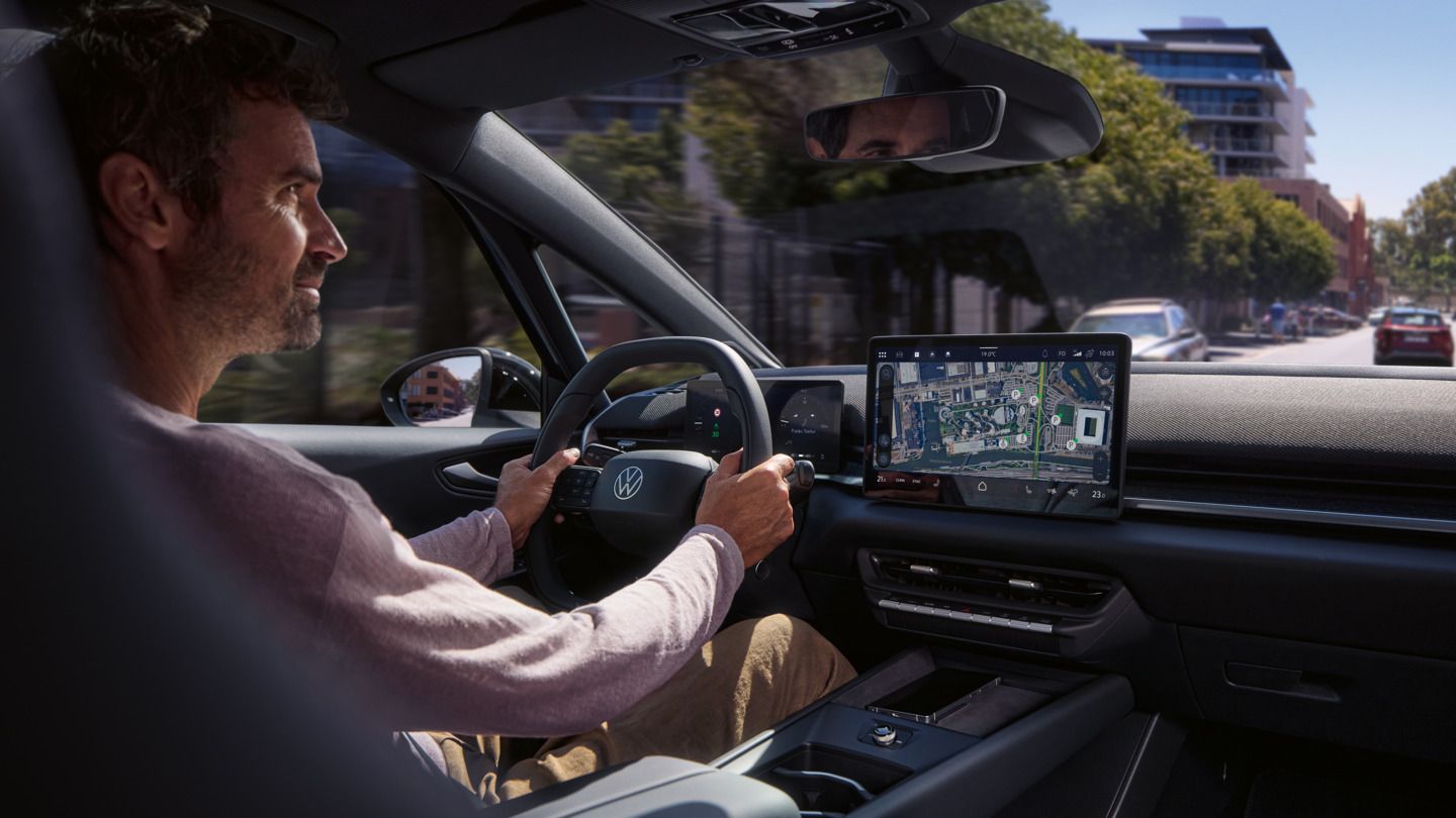 Ein Mann fährt einen VW ID.3 Neo, geleitet von der Online- Navigation auf dem Center-Display