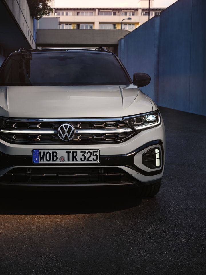 Surgem iluminados a dianteira do VW T-Roc R-Line em branco, os faróis LED de condução diurna e a grelha do radiador iluminada opcional