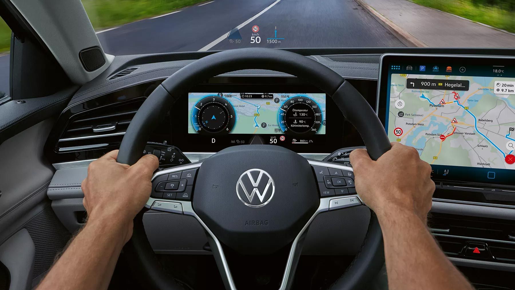 Vista interior do VW Passat focada no lado do condutor com um grande ecrã a cores e o head-up display. Duas mãos agarram o volante. 
