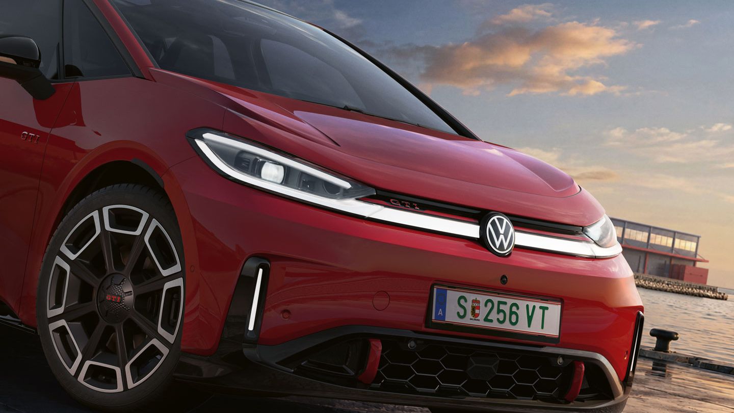 [AI-modified] – Imagem detalhada da parte dianteira de um VW ID.3 GTI vermelho estacionado com os faróis ligados e o logótipo iluminado.