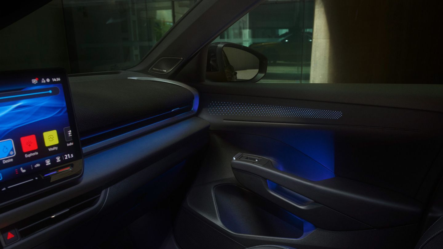 Vista do cockpit com iluminação ambiente e ecrã tátil no VW T-Roc R-Line.
