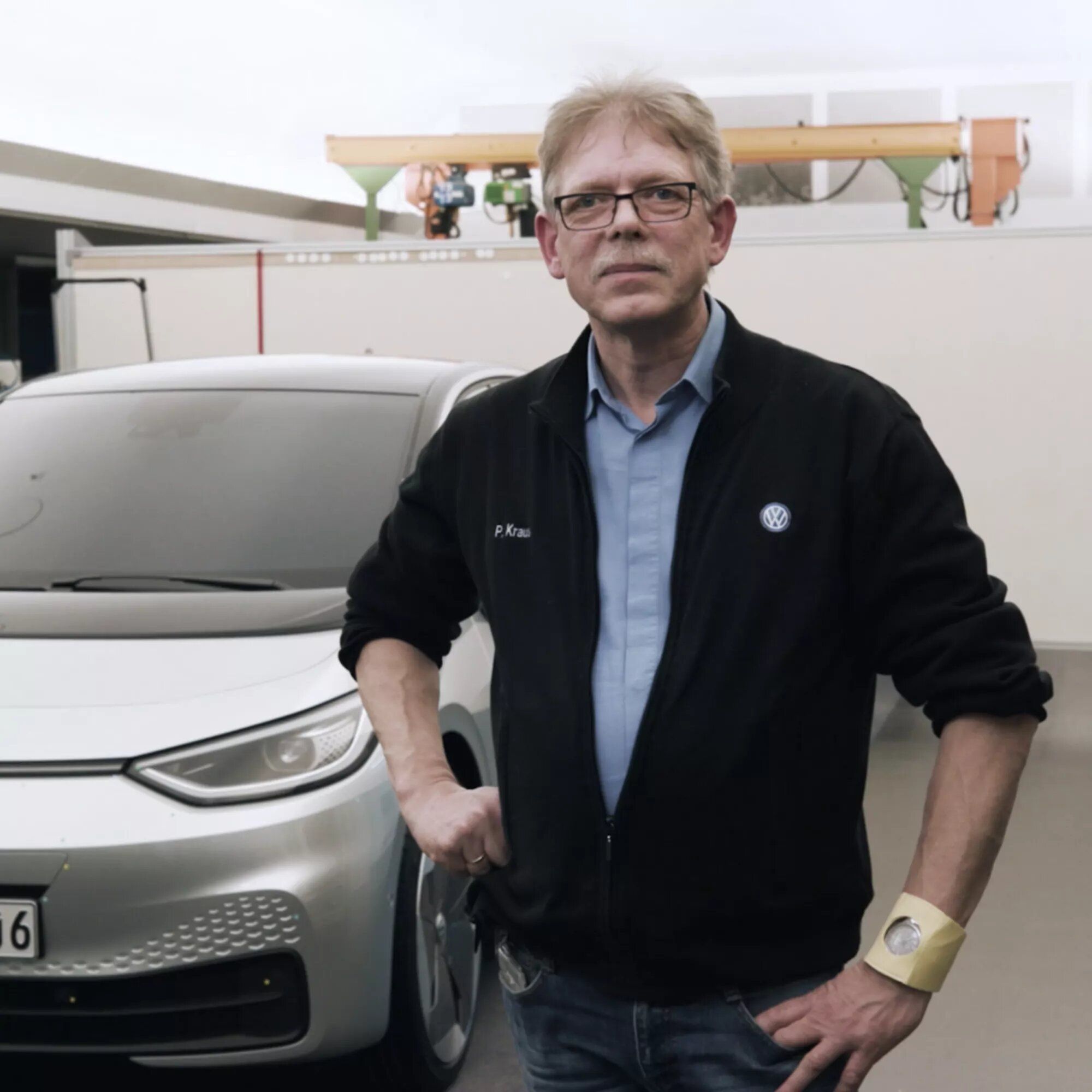 Peter Krause vor einem Auto.