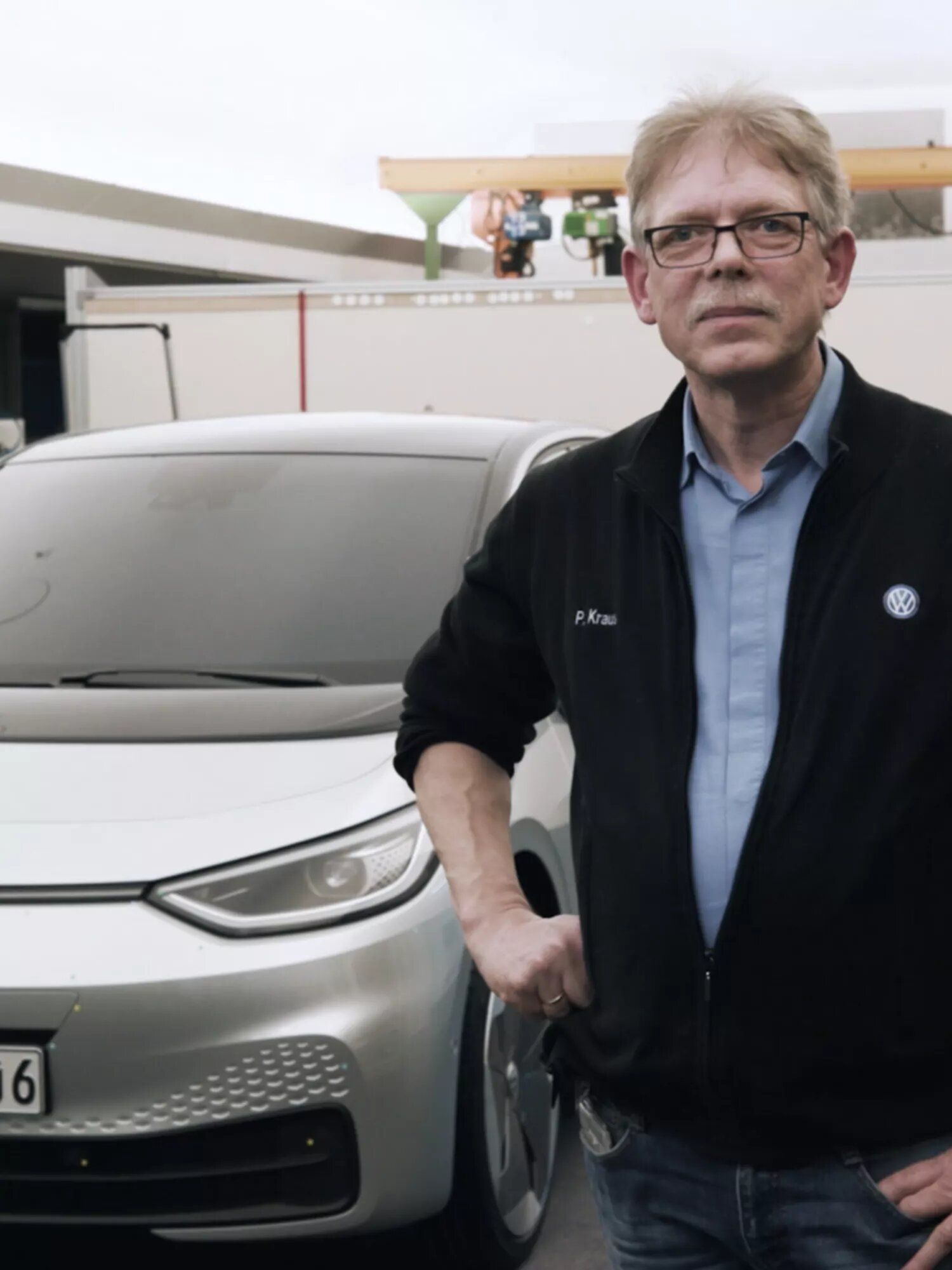 Peter Krause vor einem Auto.
