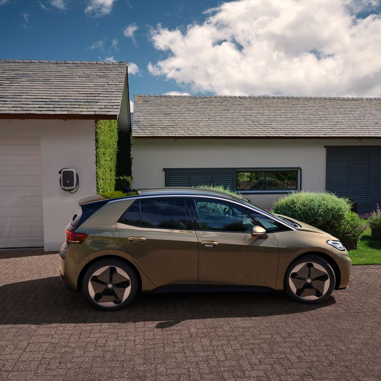 Vista de um VW ID.3 estacionado em frente a uma garagem.
