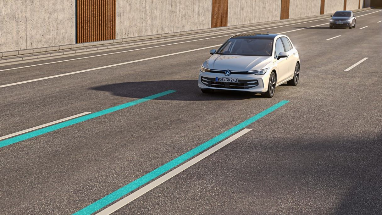 Ein weißer VW Golf nutzt den Lane Assist, um in der Spur zu bleiben.