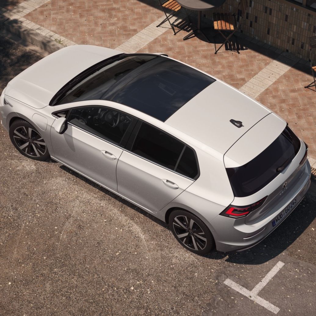 Topview auf einen weißen VW Golf mit Fokus auf das Panoramadach-Aufstell-/Schiebedach. 