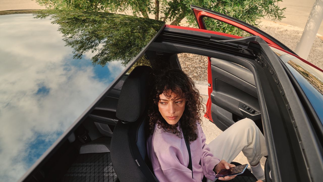 VW Taigo: Vista da mulher no banco do condutor através da abertura panorâmica/tejadilho deslizante opcional