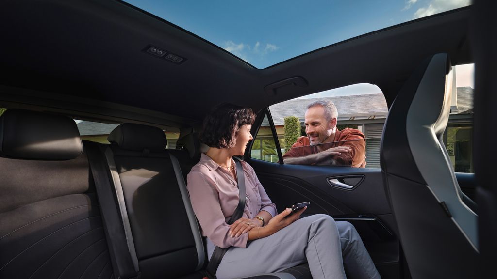 Uma mulher sentada no banco traseiro de três partes do VW ID.3.