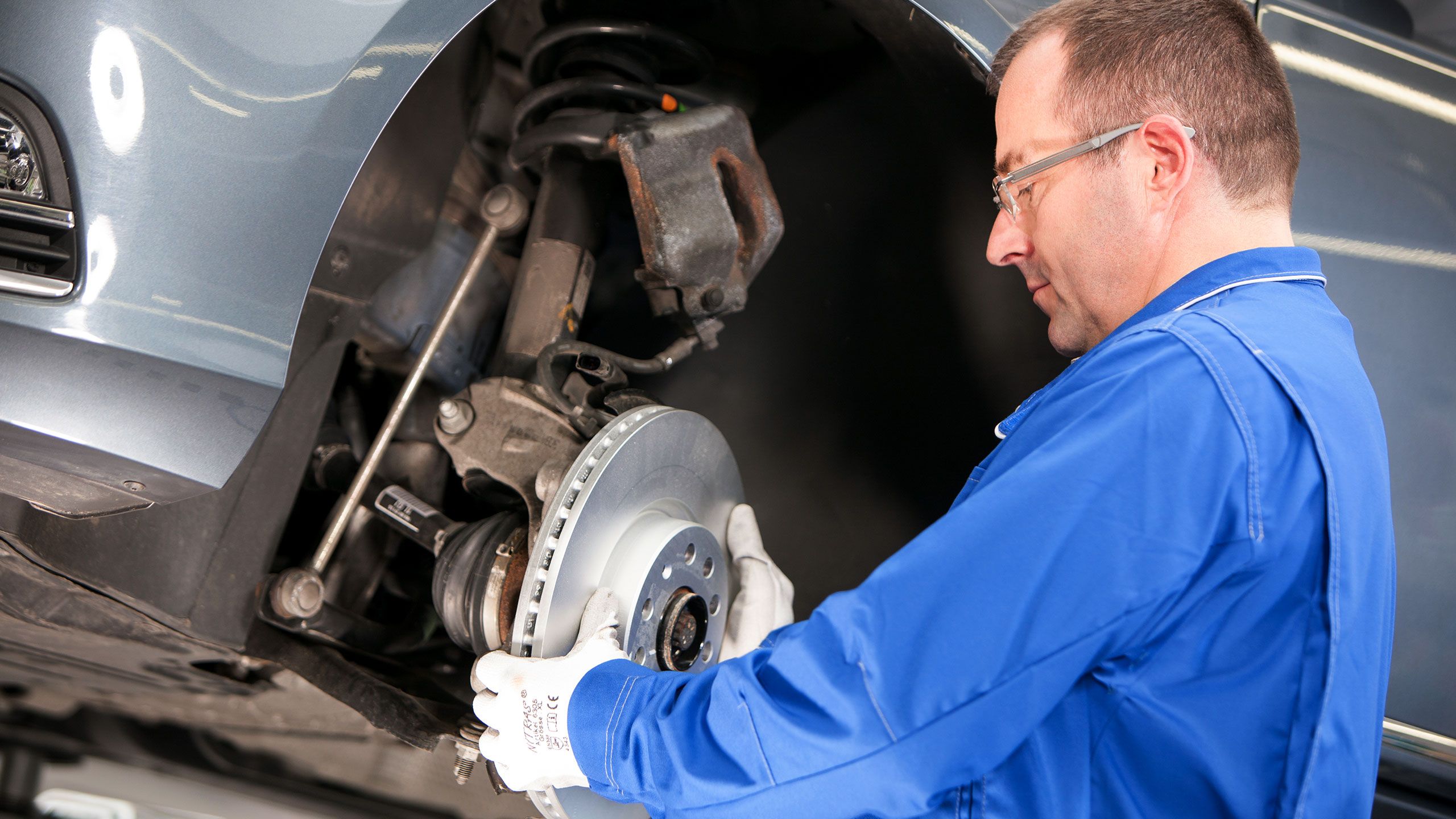 Incluído no Pacote Economy: empregado de serviço substitui uma peça economy VW no carro