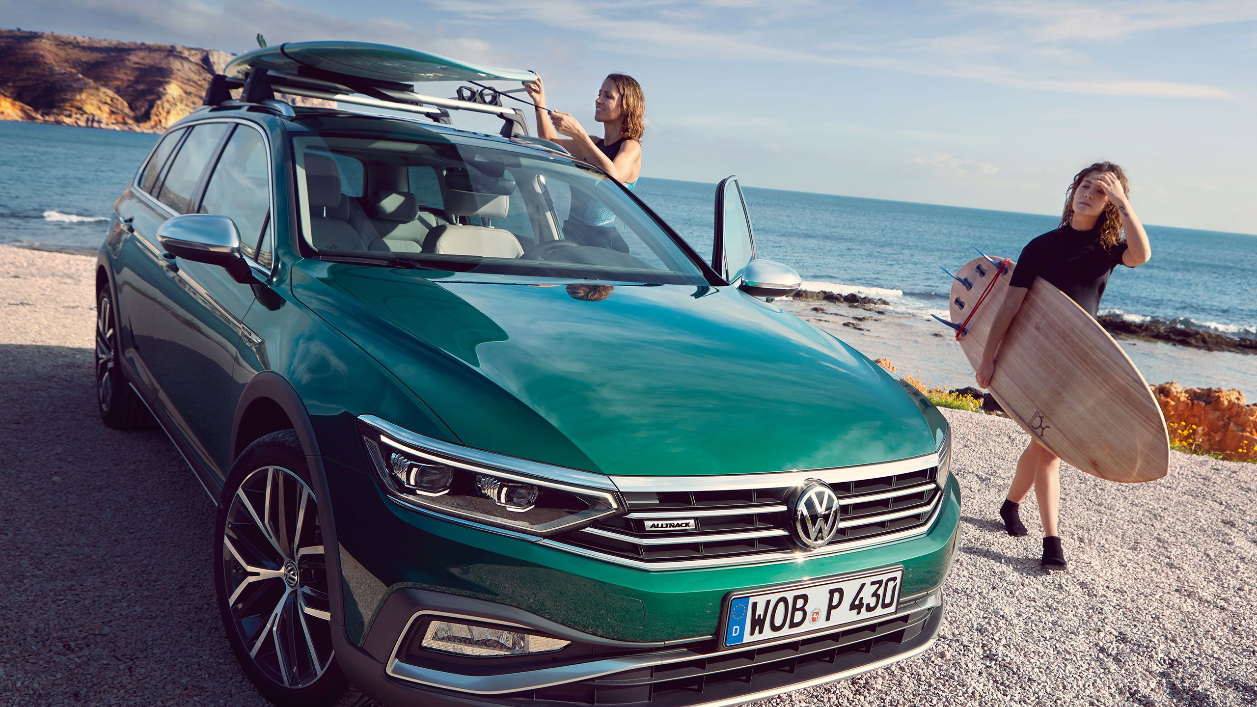 Duas mulheres vão surfar e levam as pranchas no seu automóvel VW verde