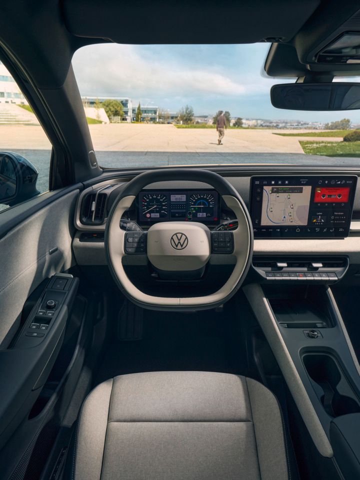 Vista frontal sobre o cockpit de um VW ID. Cross com volante multifunções e sistema Infotainment.