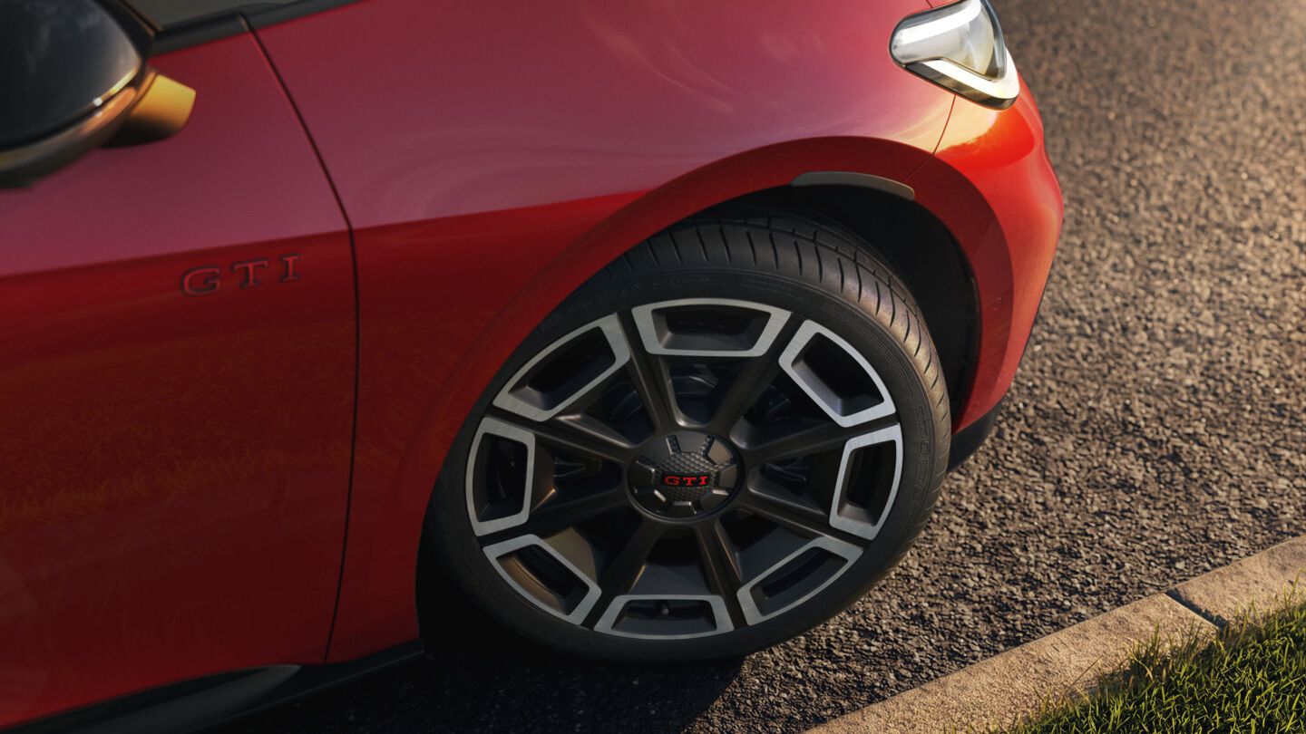 [AI-modified] – Vista frontal de um VW ID.3 GTI vermelho em frente a um edifício com os faróis ligados e o logótipo iluminado.