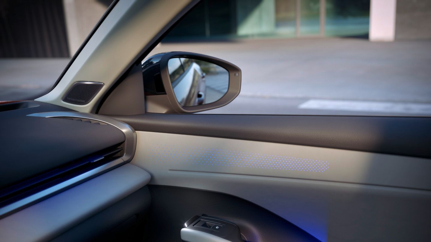 Vista do interior do Volkswagen T-Roc Style com destaque nas portas com iluminação ambiente azul.