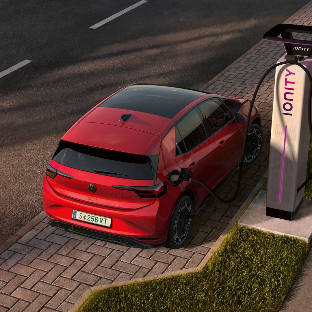 [AI-modified] – Um VW ID.3 GTI vermelho estacionado lateralmente a carregar num posto de carregamento rápido da IONITY.