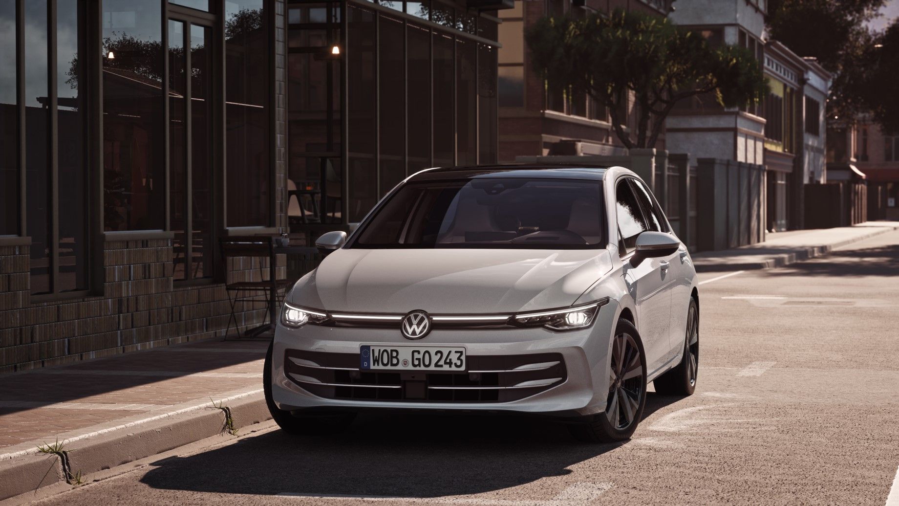 Ein weißer VW Golf von parkt seitlich vor einem Restaurant. Zwei Männer gehen in Richtung des Wagens.