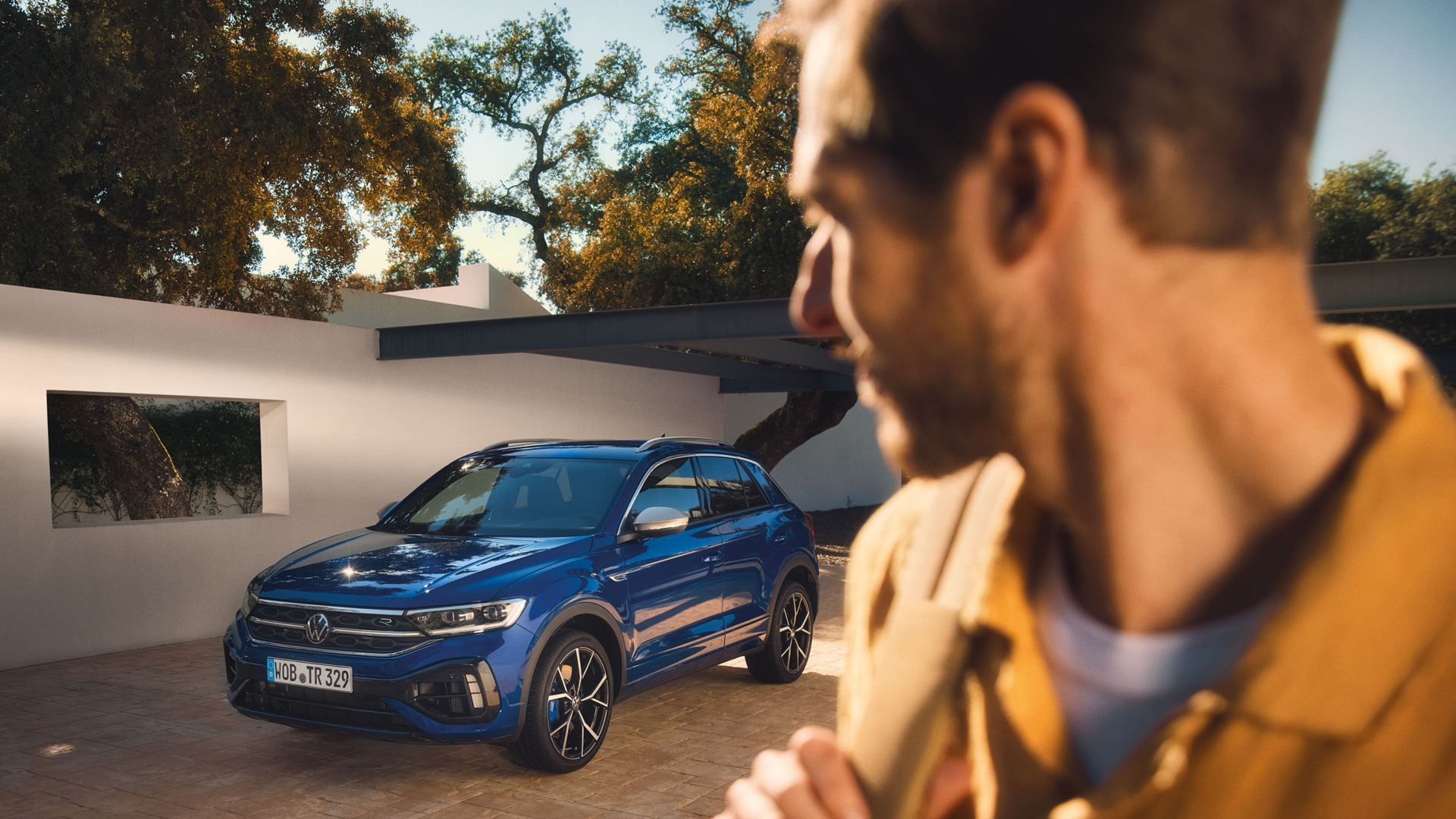 Um homem contempla o seu VW R T-Roc R estacionado num pátio
