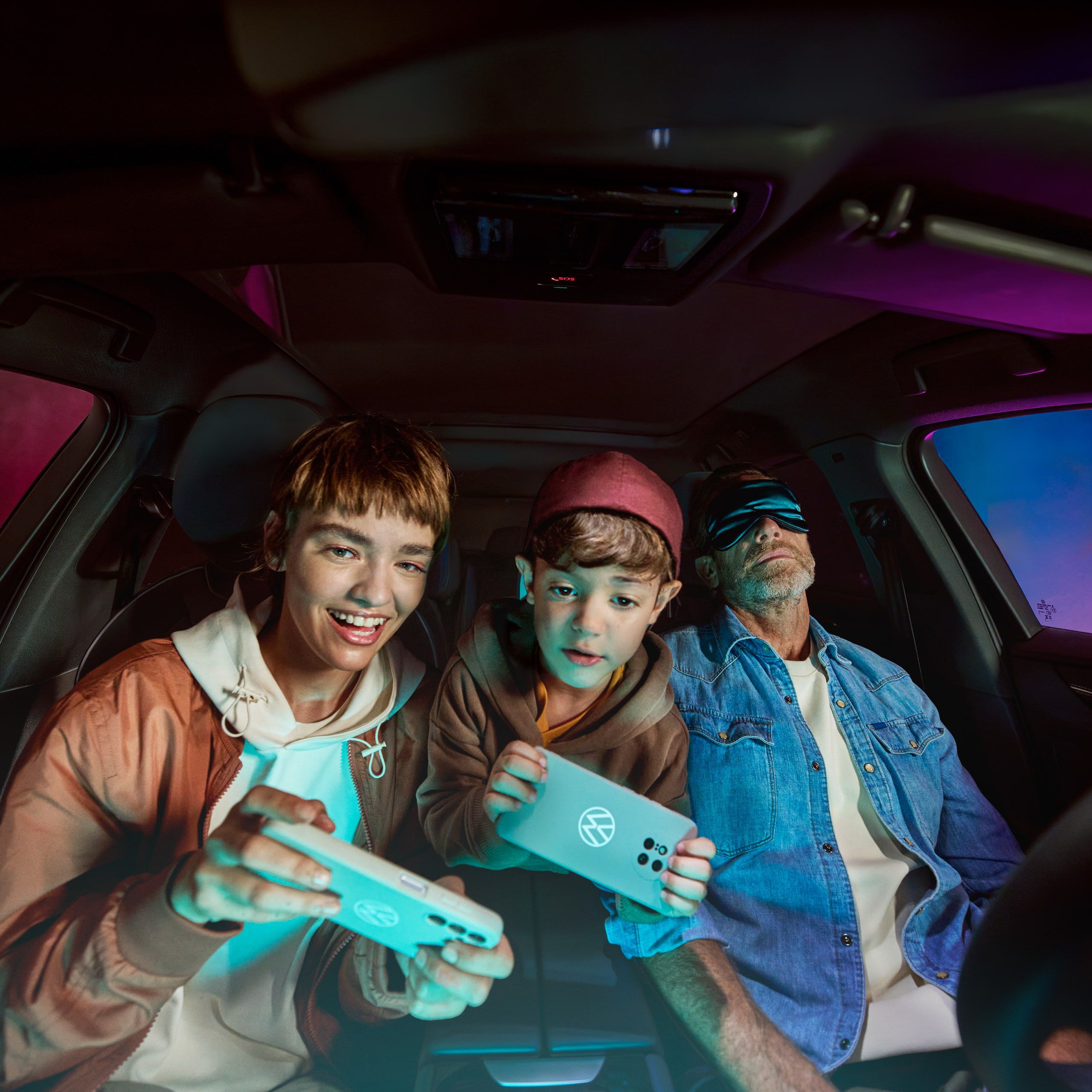 Pai com dois filhos num Volkswagen, as crianças brincam com a AirConsole.