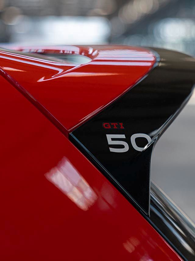 Spoiler traseiro de um VW Golf GTI EDITION 50 vermelho, em preto, com um logótipo GTI 50.