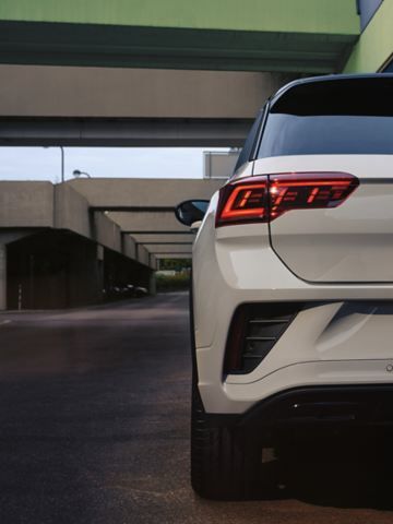 Vista de trás de um VW T-Roc branco, estacionado à beira da estrada