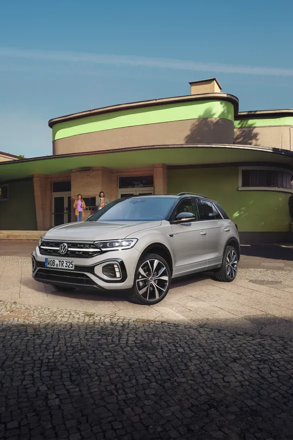 VW T-Roc R-Line em branco em frente de um edifício, veem-se a dianteira e a lateral