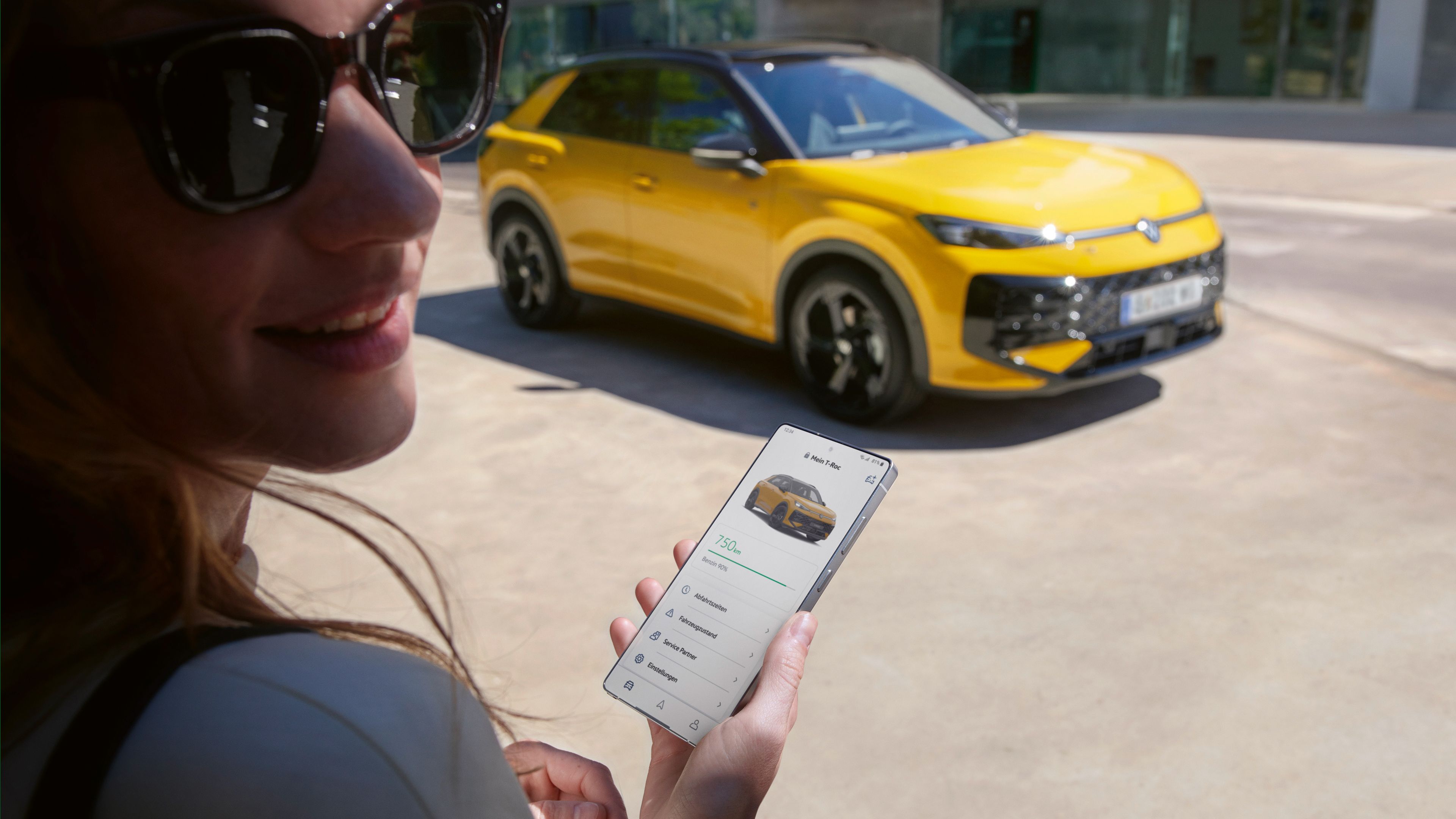 Uma mulher utiliza a aplicação VW Connect perto do seu VW T-Roc R-Line.
