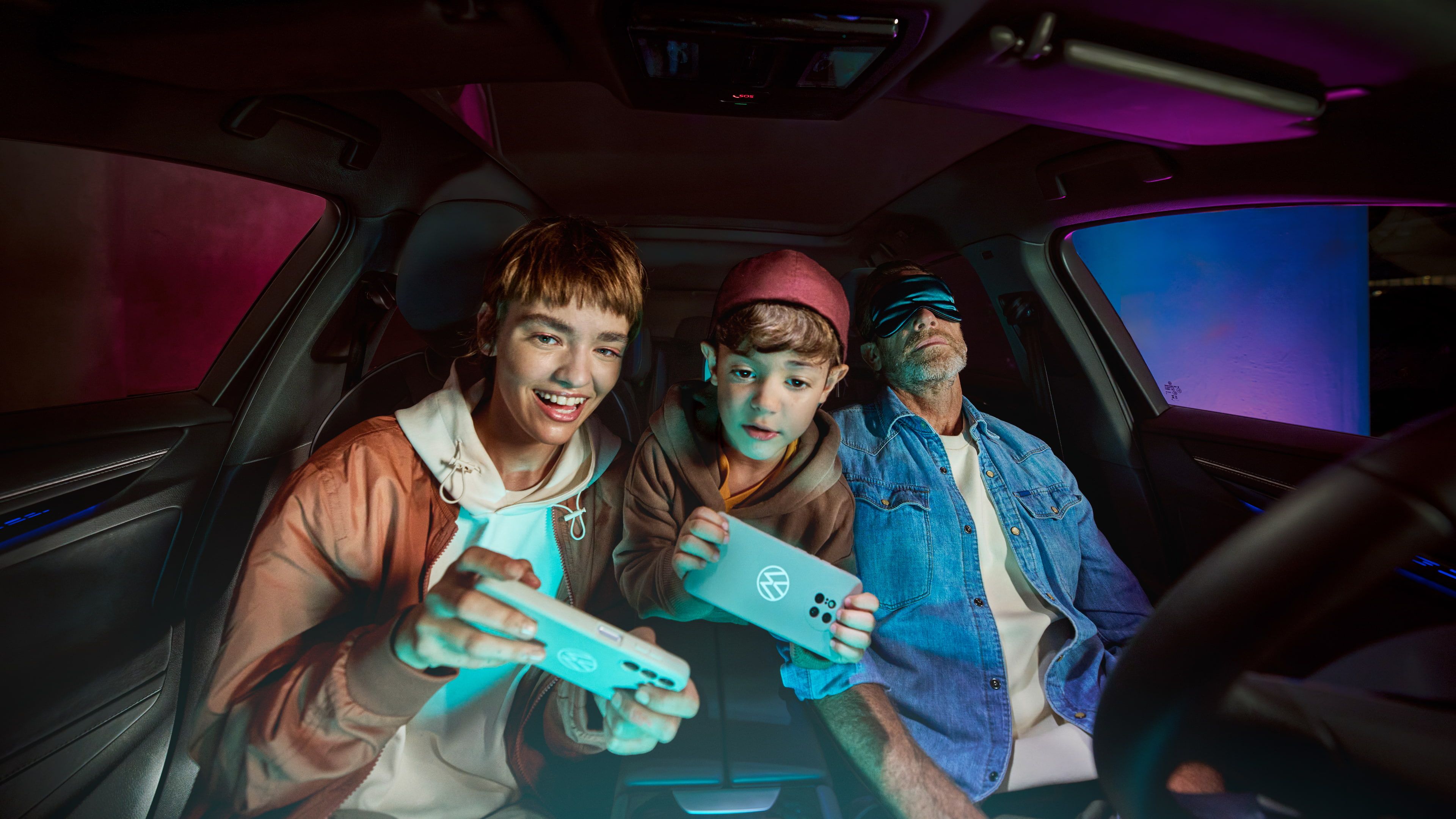 Pai com dois filhos num Volkswagen, as crianças brincam com a AirConsole.