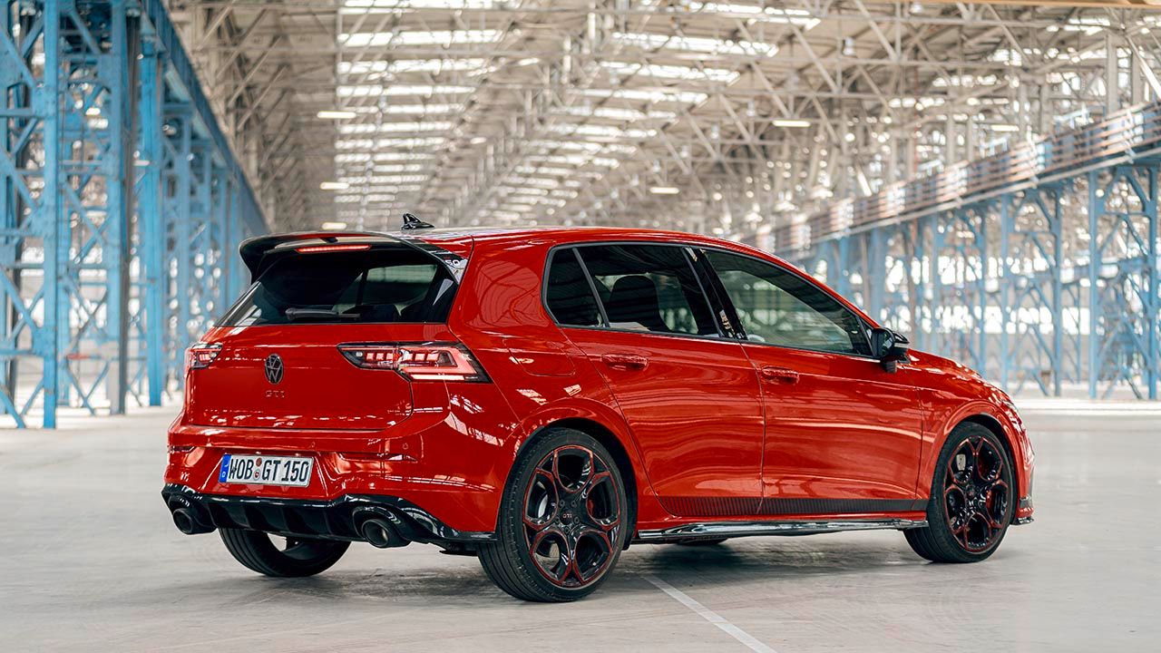 Vista traseira de um VW Golf GTI EDITION 50 vermelho estacionado num pavilhão de fábrica.