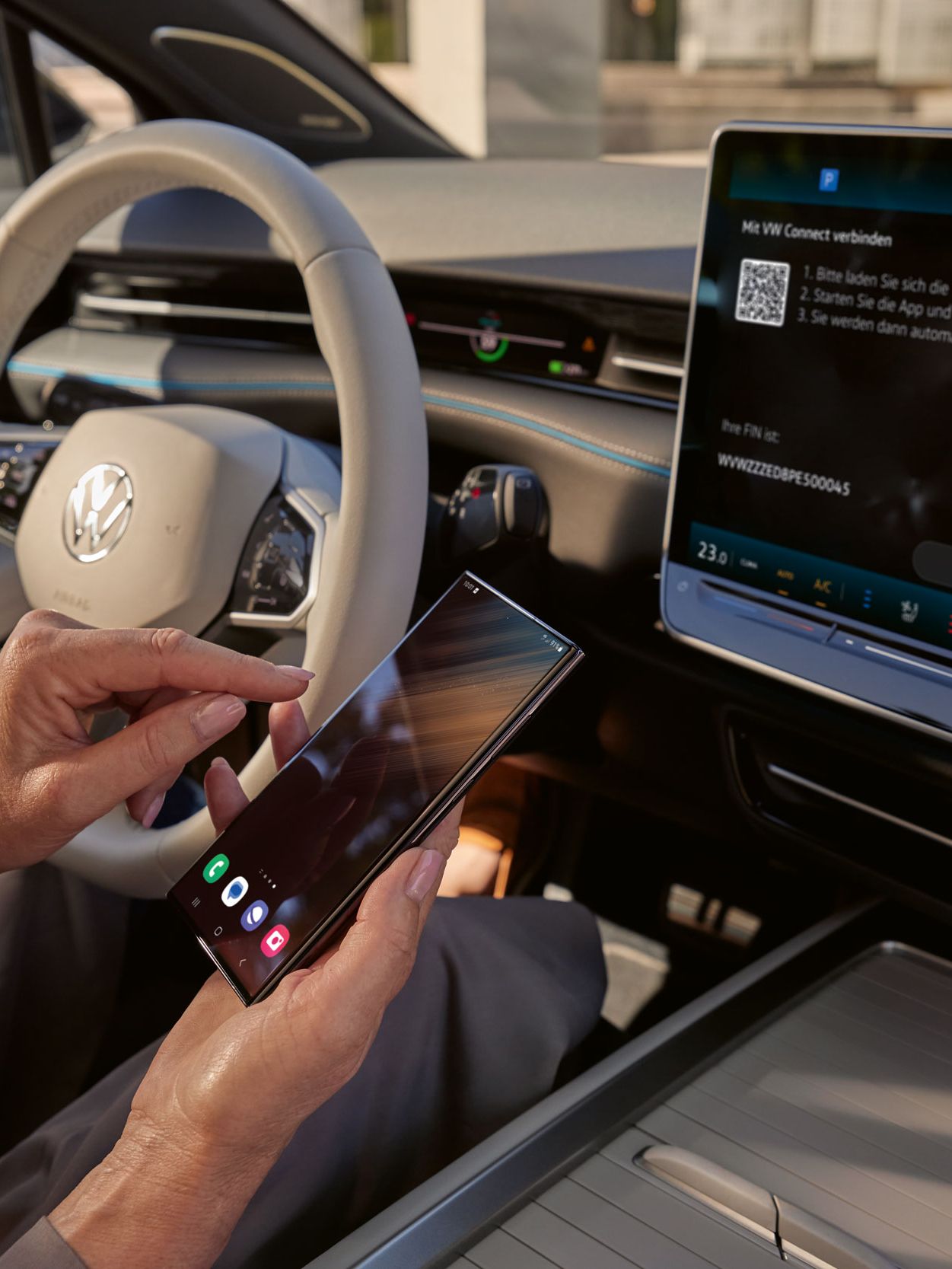 Vista sobre o cockpit no ID.7. Um smartphone está a ser ligado ao veículo via VW Connect. No visor do sistema de Infotainment vê-se a ligação ao VW Connect. 