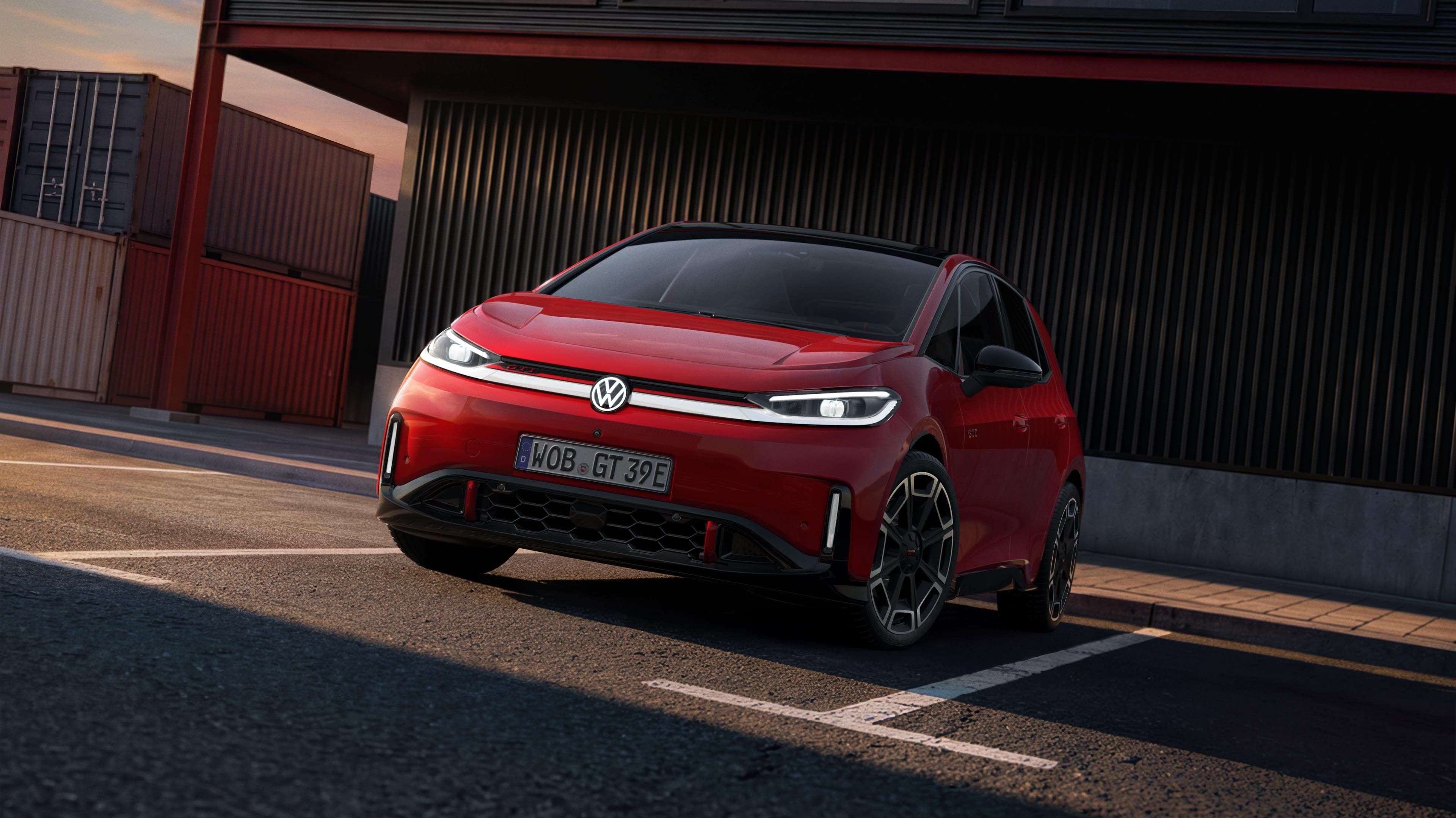 [AI-modified] – Vista frontal de um VW ID.3 GTI, com faróis e logótipo acesos, em frente a um edifício.