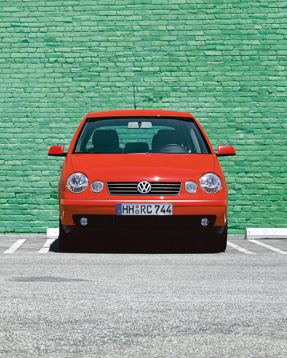 Um estacionamento VW Polo 4 tipo 9N1 vermelho em frente a uma parede verde