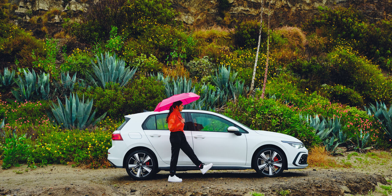 Uma mulher passa ao lado do novo carro híbrido VW Golf GTE.
