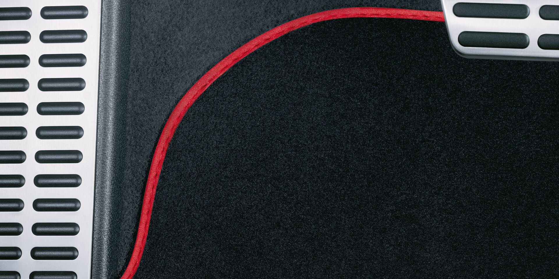 Uma vista detalhada de um tapete de golfe preto V com detalhes vermelhos dos Acessórios VW