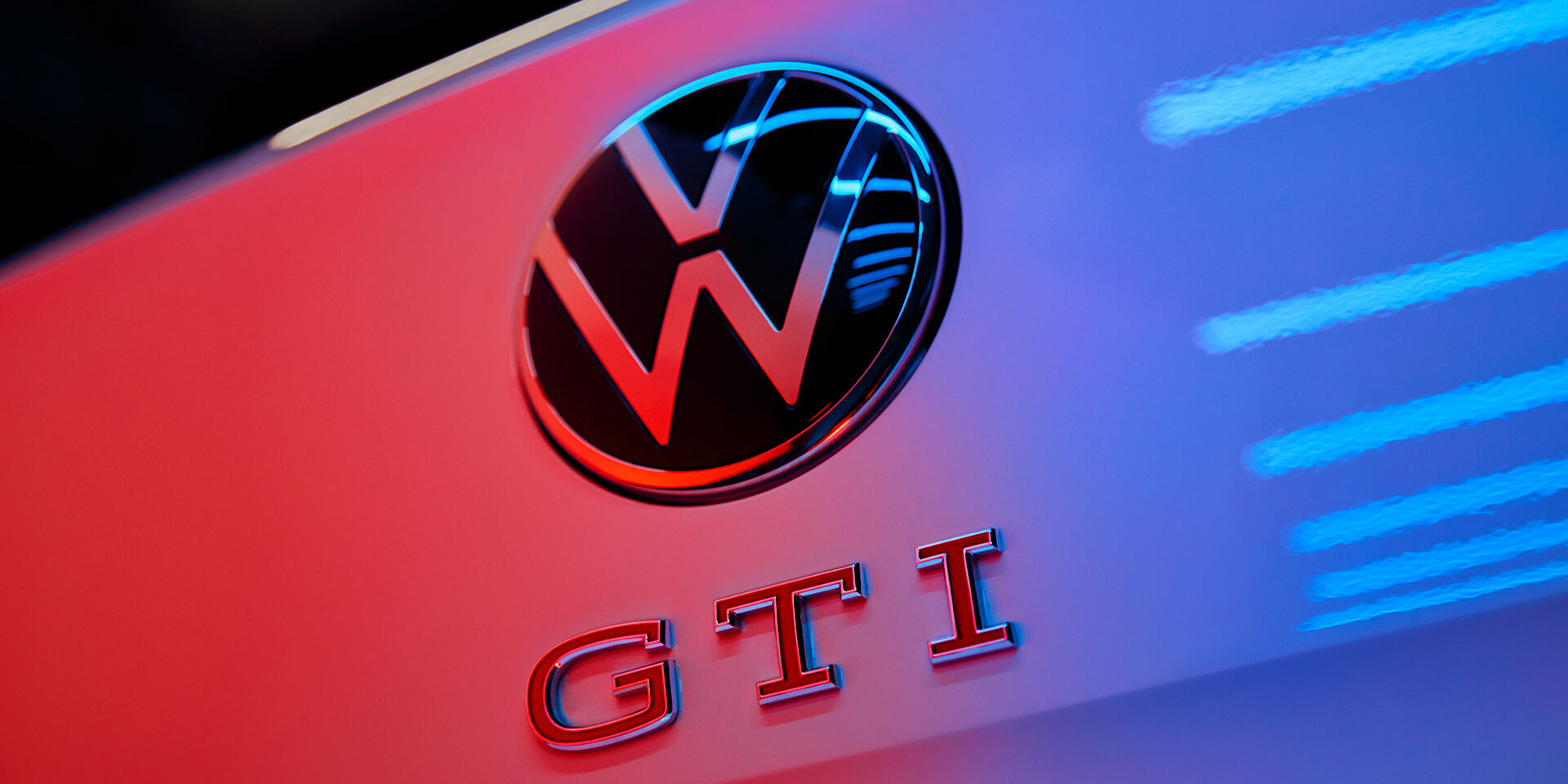 Pormenor do logótipo VW e do emblema GTI com letras vermelhas na traseira do Polo GTI.
