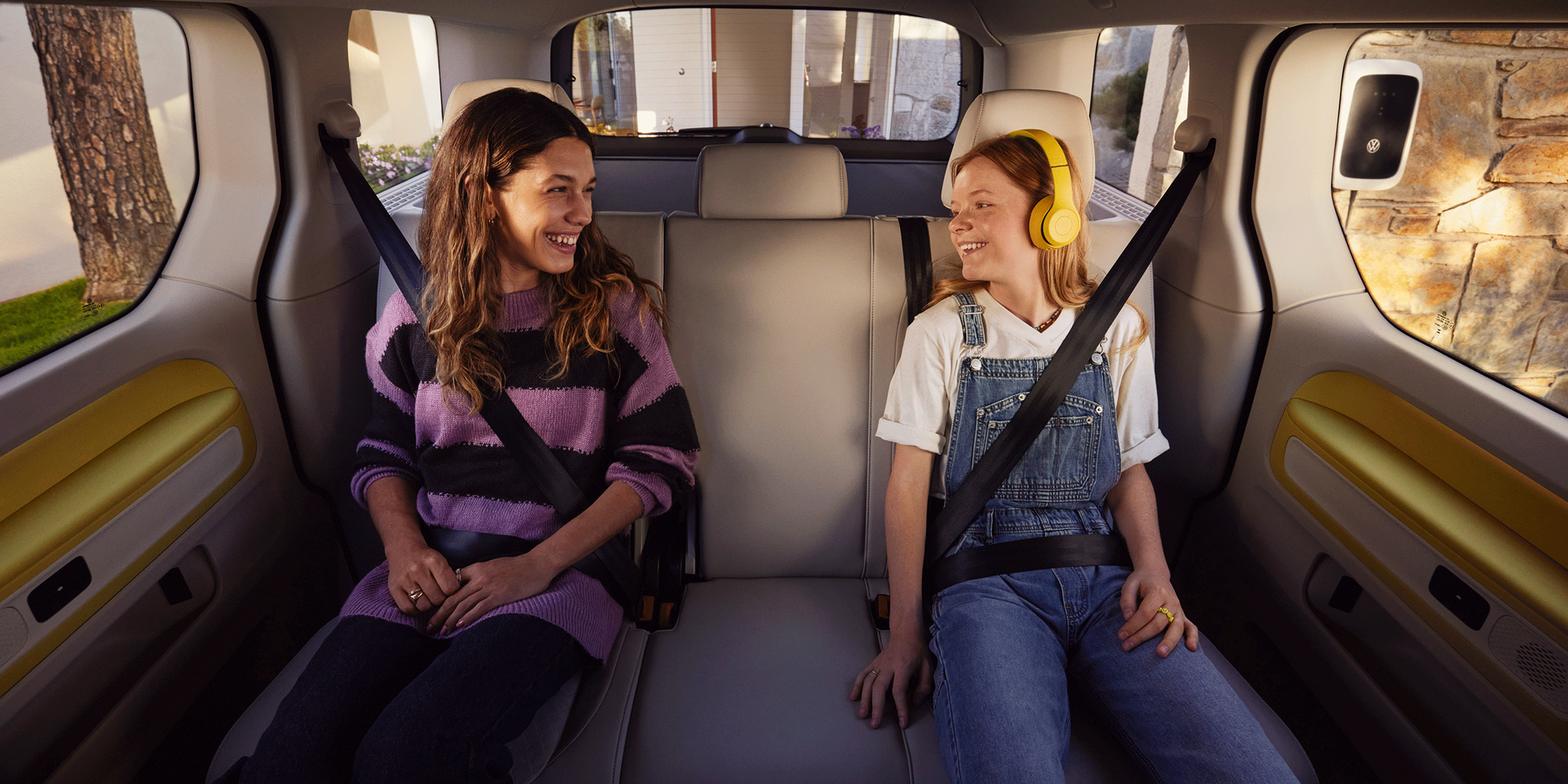 Duas raparigas sentadas no banco de trás do VW ID. Buzz.