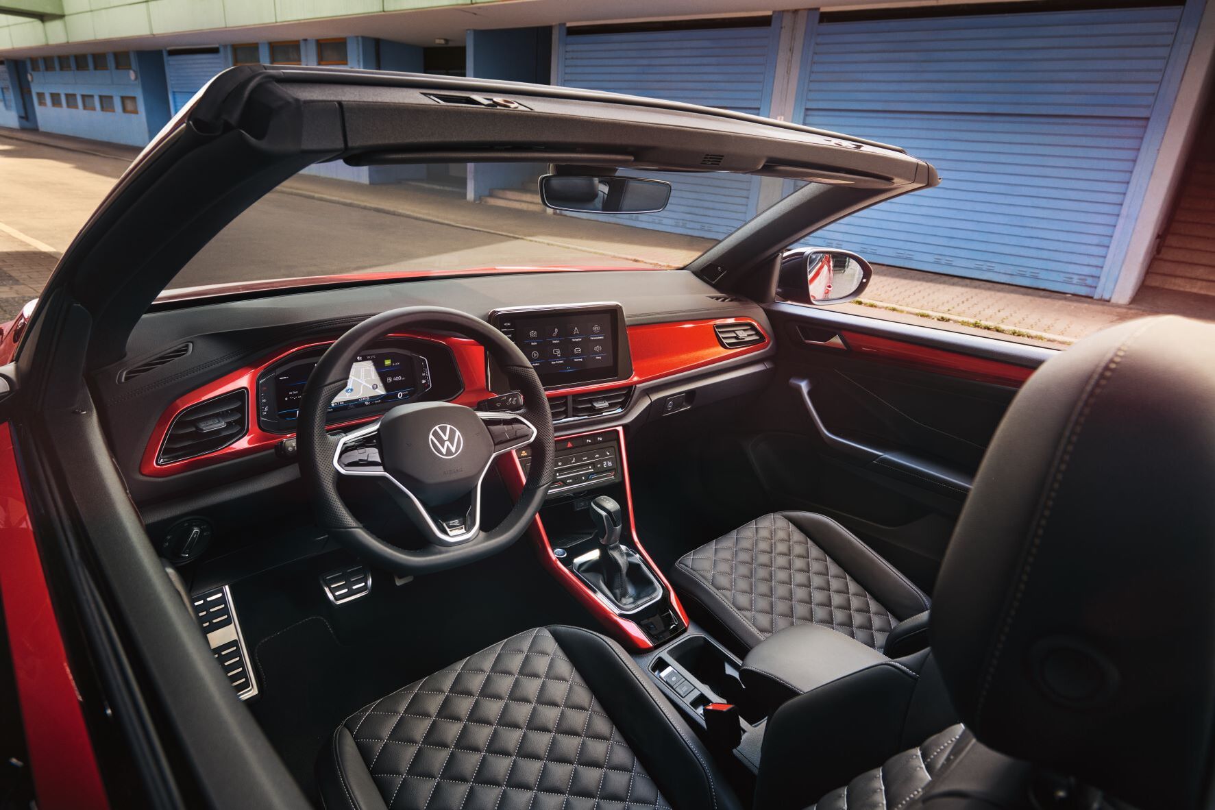 Detalhe das costuras decorativas no cockpit do VW T-Roc Cabrio, com elementos decorativos em vermelho.