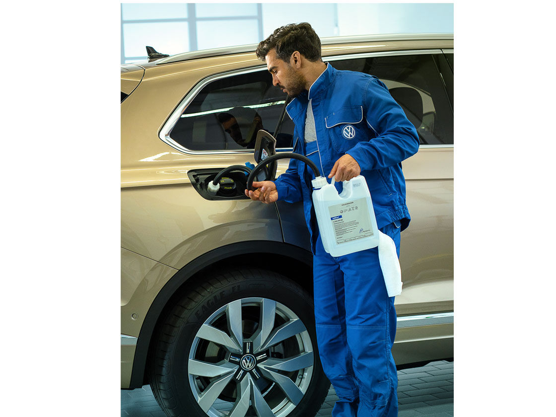 Ein VW Service-Mitarbeiter füllt AdBlue nach 